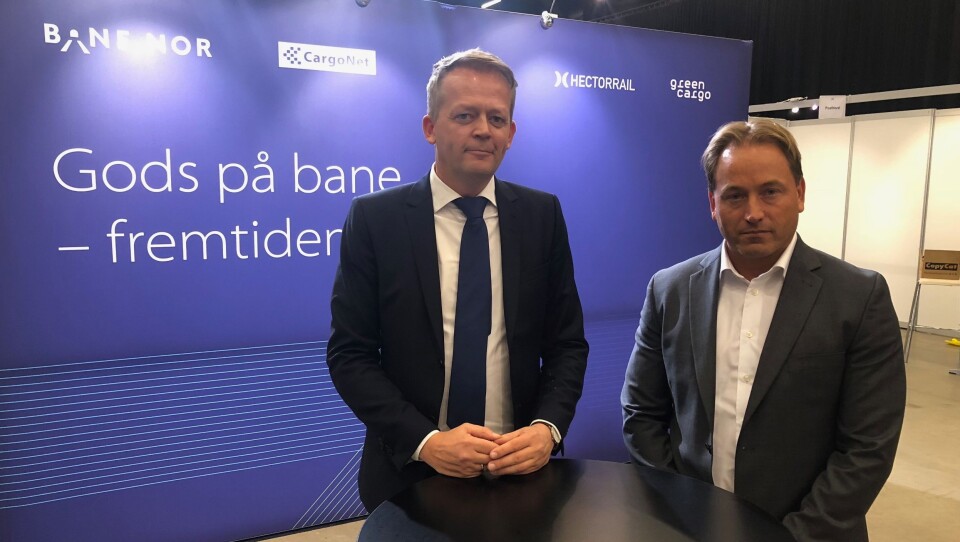 Schenkers Knut Eriksmoen (til venstre) og PostNords Robin Olsen, er slett ikke sikker på om budskapet på Bane NORs vegg på Transport & Logistikk på Gardermoen medfører riktighet.