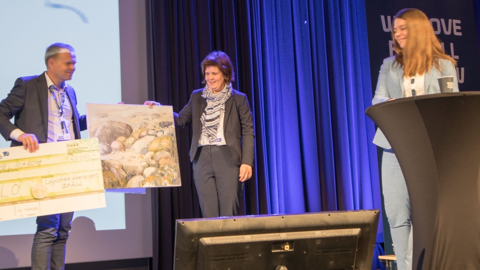 Åse Louise Rolfsøn Skogø fra FLO mottar prisen fra representanter fra styret i Logistikkforeningen Østfold.