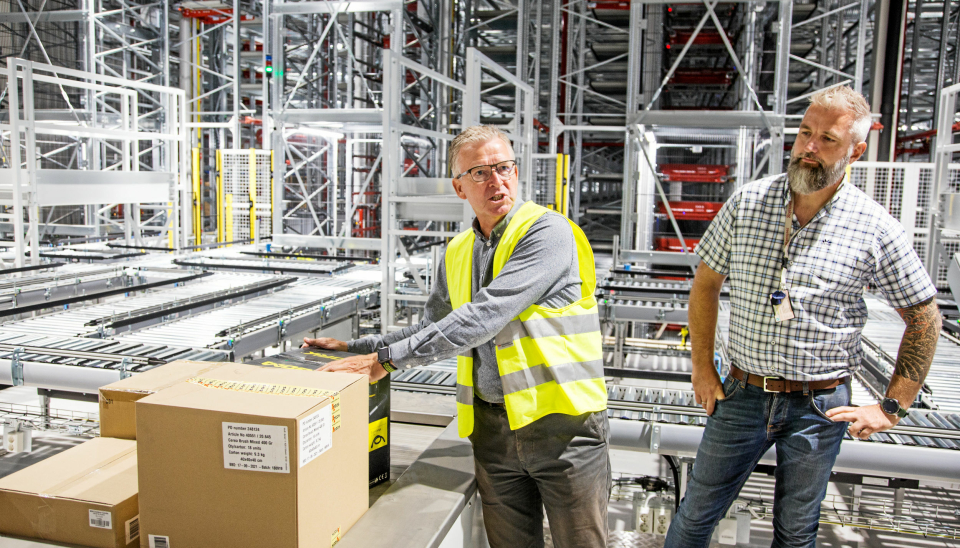 HER SKJER MAGIEN: Logistikkdirektør i Europris Pål Christian Andersen (til venstre) sammen med Swisslogs prosjektleder Øystein Araldsen, ved en av seks plukkstasjoner for plukking av ordrepall.
