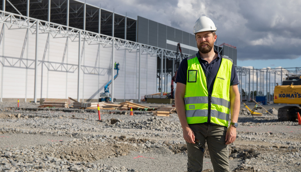Audun Tharaldsen, logistikksjef i Optimera, foran bygget under oppføring.