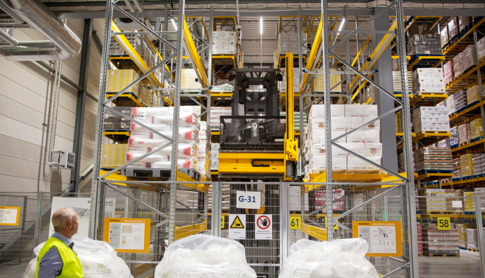 OVERLEVERING: En av de ni AGV-ene leverer en pall på overleveringsstasjonen og tar samtidig med en pall tilbake inn på lageret. Ragnar Pettersen i Jungheinrich følger med.