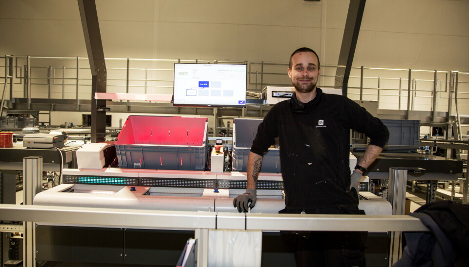 KJAPPERE OG ENKLERE: Christian Myhre forteller at plukkprosessen er mye mindre tidkrevende enn tidligere og at det omtrent er umulig å gjøre feil. Varer skal plukkes fra kassen det lyser rødt i, og legges i esken i brønnen med det grønne lyset. Skjermen forteller hvor mange enheter, og stasjonen foretar en kontrollveiing for å sikre mot feil.