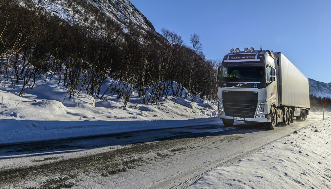 Volvo 540 freight truck driving in a winter landscape in Northern Norway hauling a cargo trailer near the village of Gryllefjord on the island Senja. Lastebil