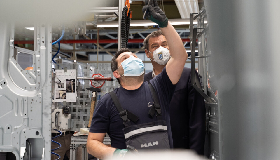 MANs lastebilproduksjon i München startes opp igjen. MAN-ansatt til (t.v.) og statsminister Markus Söder i Bayern på fabrikken. MANs lastebilproduksjon i München startes opp igjen. MAN-ansatt til (t.v.) og statsminister Markus Söder i Bayern på fabrikken.
