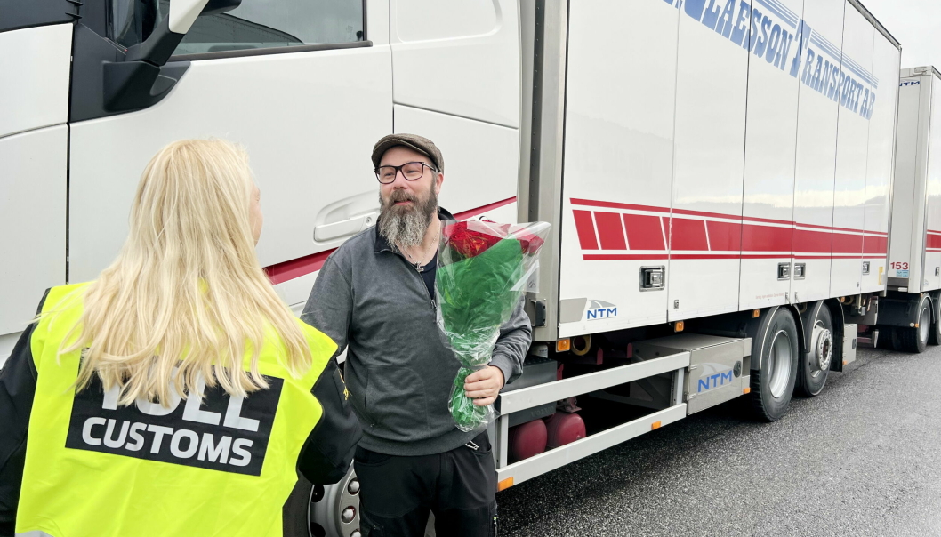 Seksjonsef Ann-Kristin Signebøen overrekker blomster til Joakim Abrahamsson fra G. Claesson Transport AB. 46-åringen var den første som passerte tollstasjonen under den nye Digitoll-løsningen.