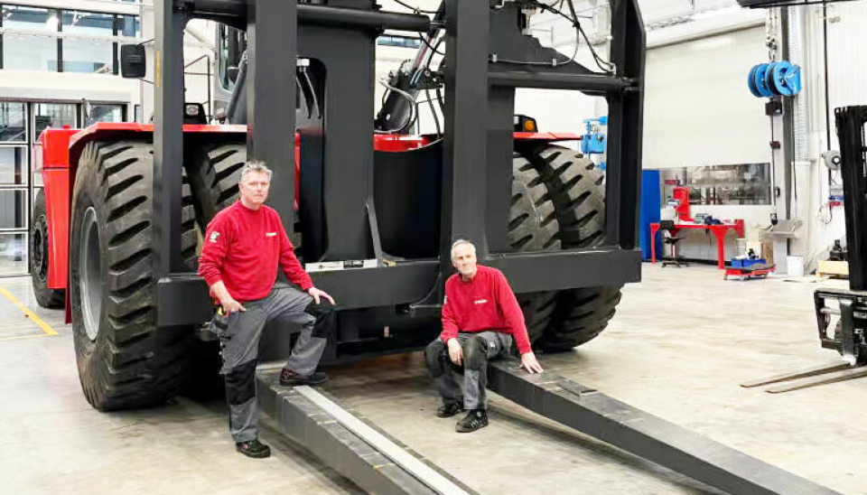 En vanlig person blir liten foran Kalmars nye 85-tonner. Her demonstrerer Kalmars teknikere Tord og Peter dimensjonene på trucken.