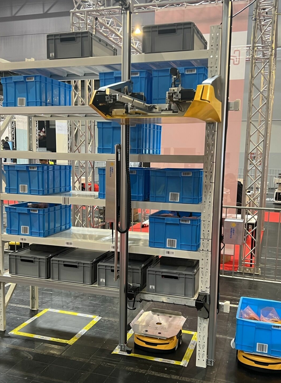 Robotene til Airrob henter kasser i hyller opptil 14 meter høye, og kan servere dem til små AMR-er som frakter dem videre.