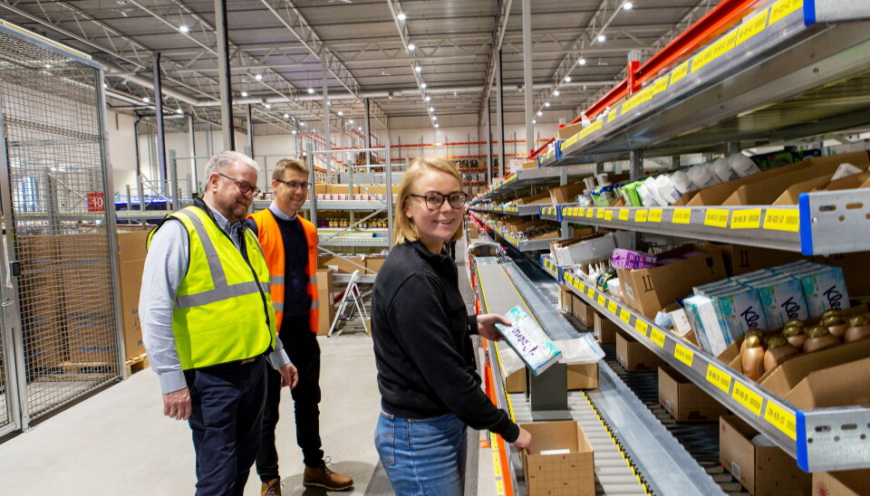 SYDD SAMMEN: Logistikkdirektør Ane Wisløff-Høgestøl viser den delen av plukkprosessen som fortsatt er bittelitt manuell, mens EABs Runar Bøe og Øystein Granslo følger med. EAB har levert gjennomløpsreolene det her plukkes fra, mens Knapp har levert automasjonen, blant annet conveyoren som sørger for at rett eske kommer til rett plukker på rett posisjon. Eskene svinger innom er om manuelt plukk er nødvendig etter at A-frame-løsningen har levert de varene den ska.