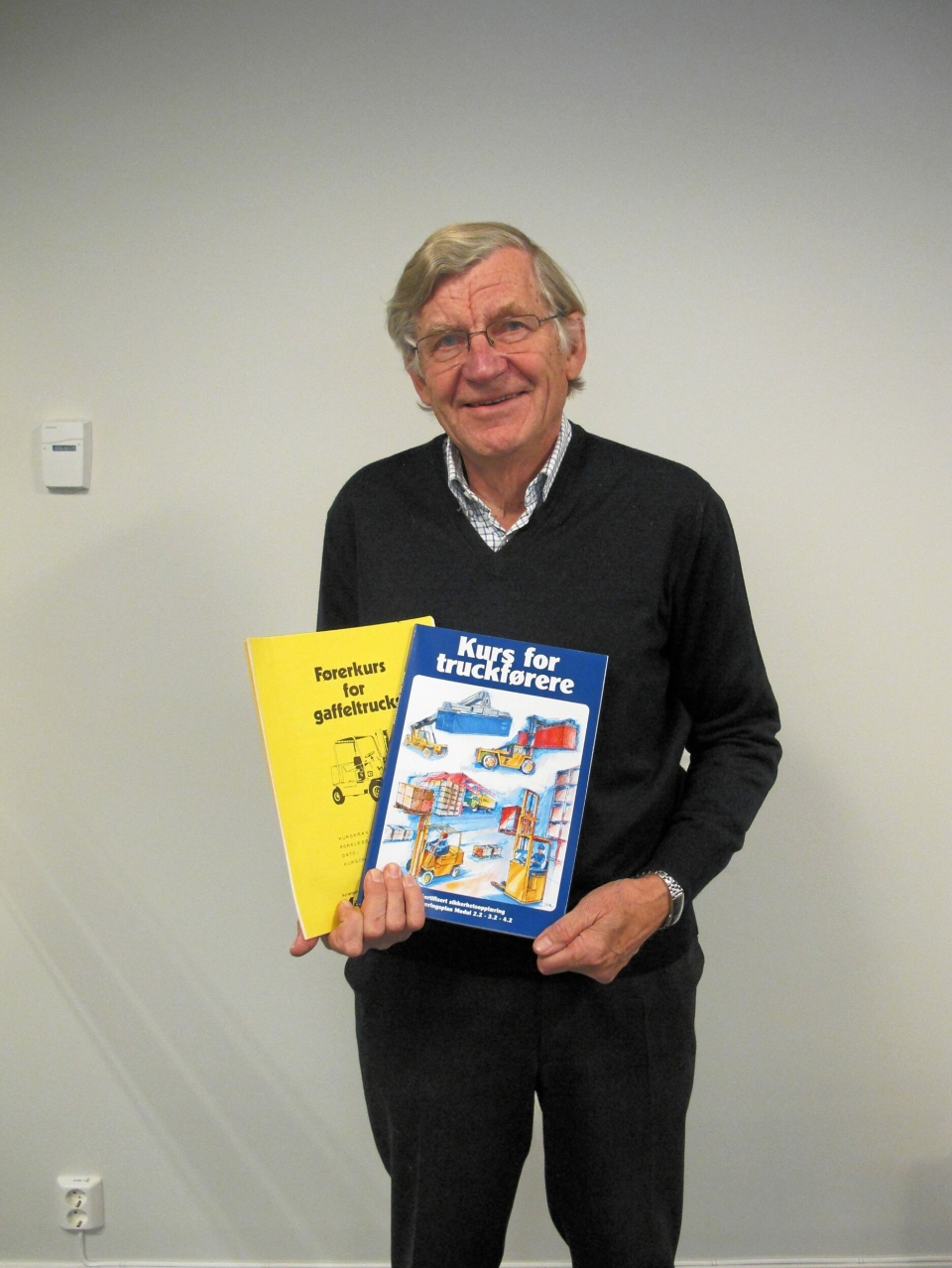 FØRST OG SIST: Gunnar Luthen med den første og den siste kursboken for truckførere han har laget.